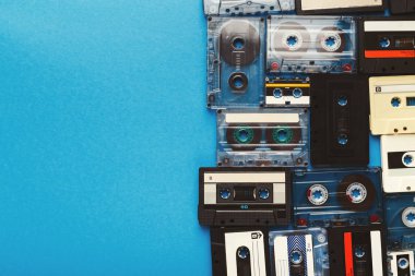 Vintage audio cassettes border on blue background clipart