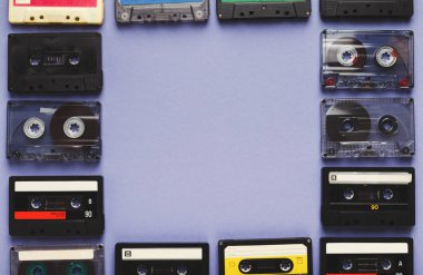 Vintage audio cassettes frame on violet background clipart