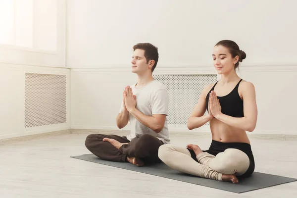 Ungt par öva yoga sitter i padmasana — Stockfoto