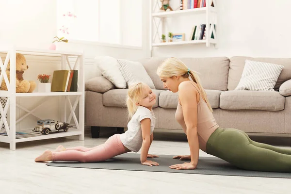Mother and daughter doing yoga exercises at home — Stock Photo, Image