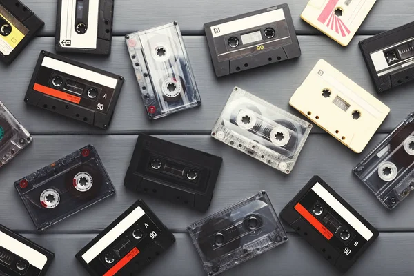 Hoop van vintage audio cassettes bij grijze planken achtergrond — Stockfoto