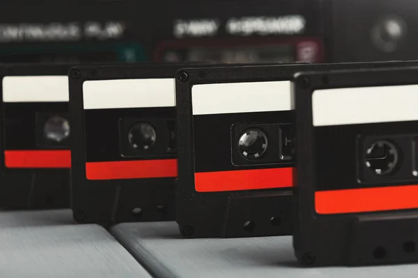 Reihe alter Audiokassetten und Tonbandgerät auf grauem Hintergrund — Stockfoto