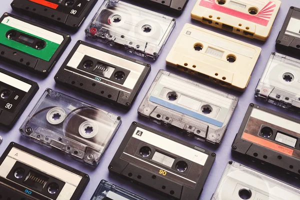 Vintage audio cassettes on violet background, closeup