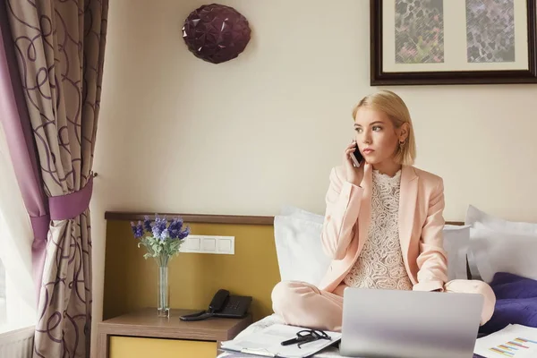 Porträtt av affärskvinna sitter på sängen och använder bärbar dator — Stockfoto