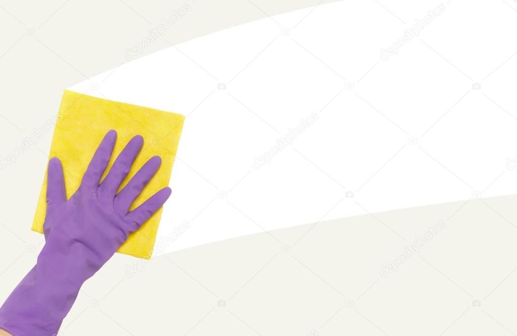Hand in rubber glove wiping white wall from dust