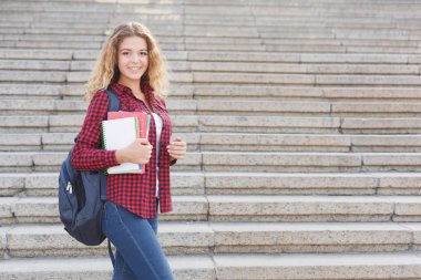 Kız öğrenci ile defter açık havada duran