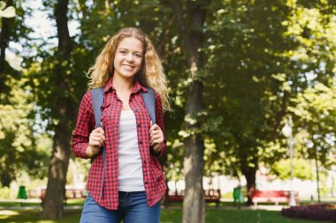 Mutlu kız öğrenci parkta duran