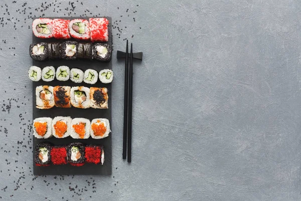 Sushi, maki och rullar på grå bakgrund — Stockfoto