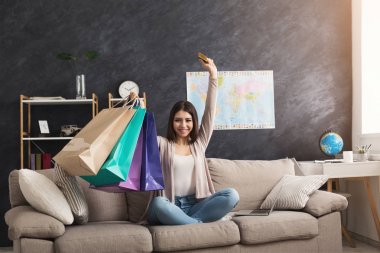 Mutlu kadın laptop ve kredi kartı ile online satın alma