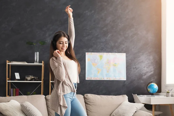 Junges lächelndes Mädchen mit Kopfhörern, das Musik hört — Stockfoto