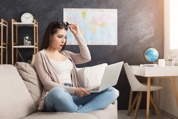 Donna sorpresa che lavora sul computer portatile a casa — Foto Stock