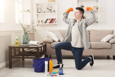 Young man cleaning home and having fun clipart