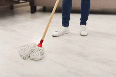 Unrecognizable woman with mop ready to clean floor clipart