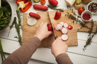 Kadın kesme taze turp ahşap tahta üzerinde