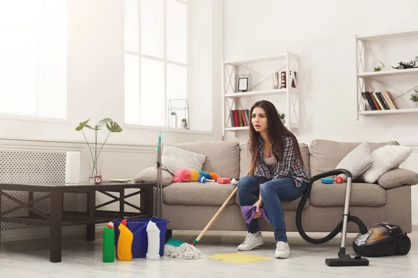 Mujer impactada casa de limpieza con un montón de herramientas — Foto de Stock