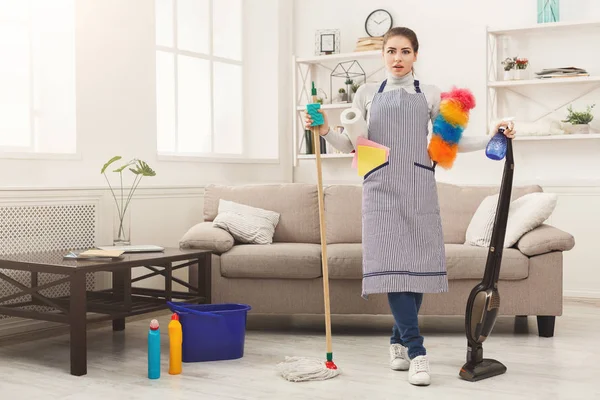 Šokovaná žena úklid domu se spoustou nástrojů — Stock fotografie