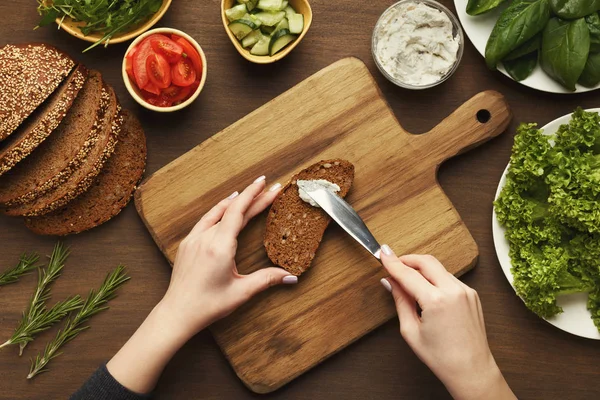 Top view on female hands making vegetable bruschettas — Stock Photo, Image