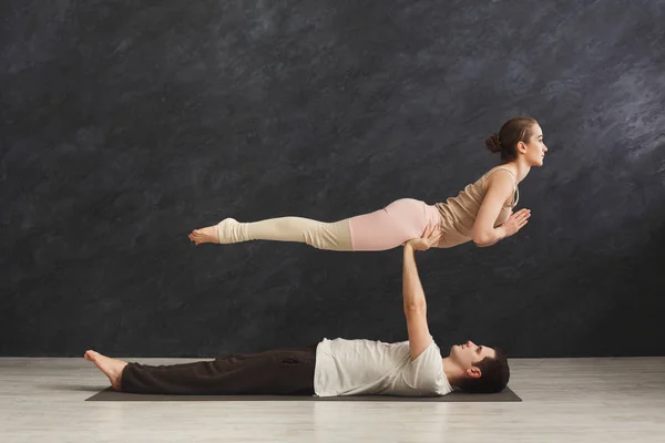 若いカップルが一緒にマットで acroyoga の練習 — ストック写真