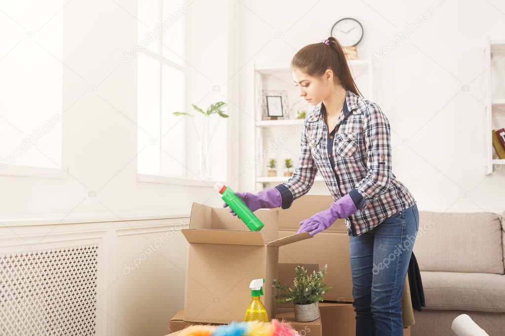 Young woman unpacking boxes after moving