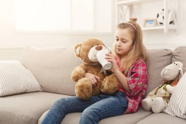 Sevimli küçük kız çayını onun arkadaşı ayıcık ile paylaşımı