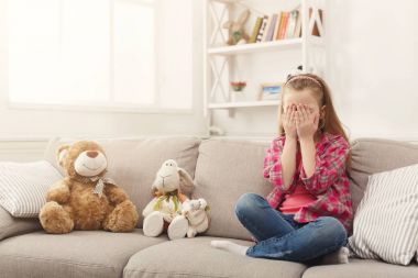 Evde kanepede otururken TV izlerken rahat küçük kız korkuyor