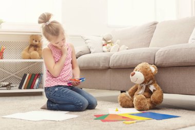 Gülümseyen küçük kız evde renkli kalemler ile çizim