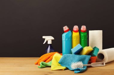 Colorful group of cleaning supplies on dark background clipart