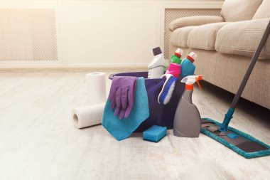 Kova sünger, kimyasallar şişeleri ve paspas sopa ile.