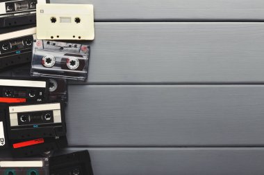 Vintage audio cassettes border on gray planks background clipart