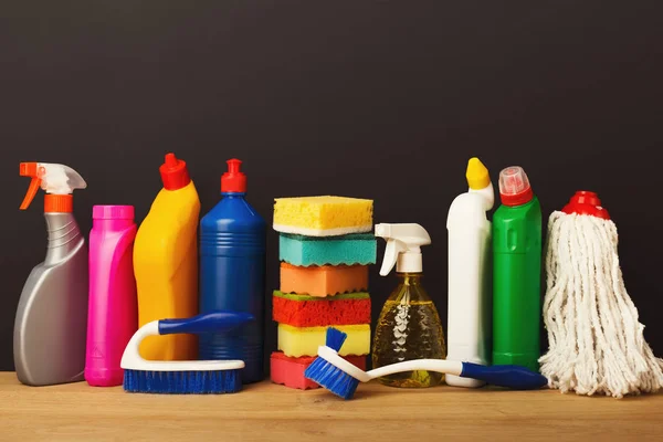 Grupo de produtos de limpeza coloridos em fundo escuro — Fotografia de Stock