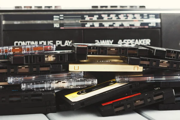 Montón de casetes de audio vintage y grabadora de cinta en fondo gris — Foto de Stock