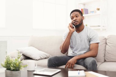 Kızgın genç adam evde cep telefonunuzda konuşuyor