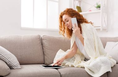 Evde boş vaktinizi. Tablet ve telefon ile düşünceli kız