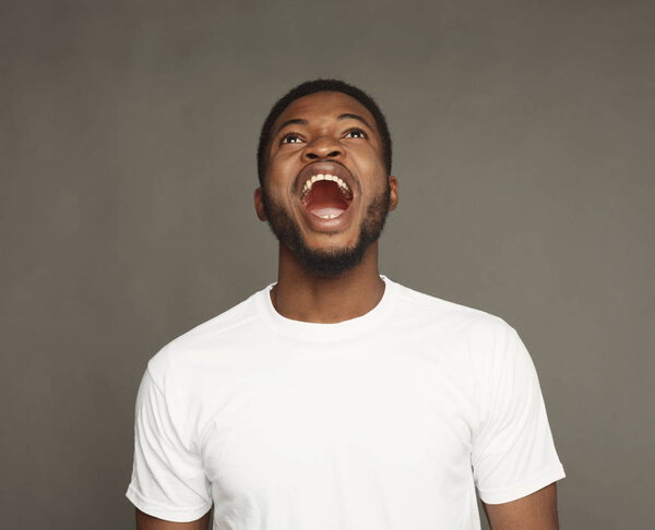 Black man expressing anger, feeling furious, shouting