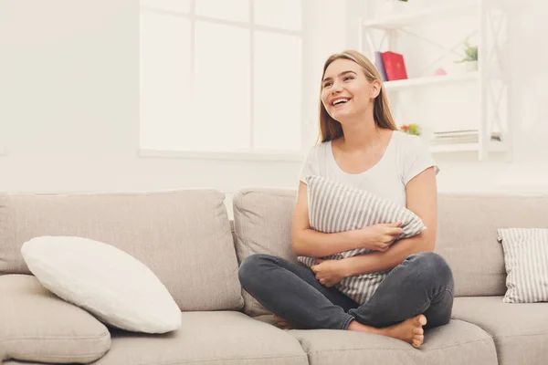 Junge lächelnde Frau auf beigem Sofa — Stockfoto
