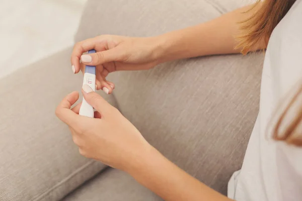 Крупный план женских рук с положительным тестом на беременность — стоковое фото