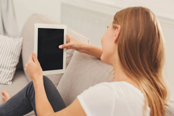 Giovane donna che utilizza tablet a casa sul divano — Foto Stock