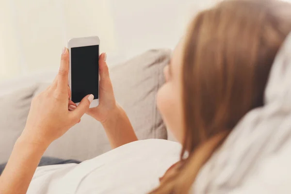 Девушка дома в чате онлайн на смартфоне — стоковое фото