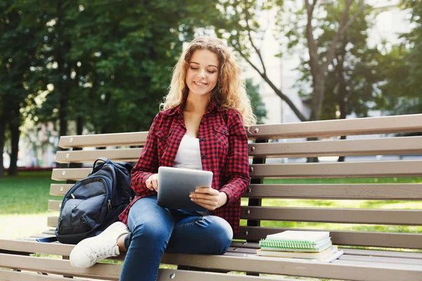 Mulher sorridente no parque com tablet — Fotografia de Stock