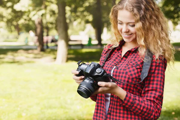 Woman taking photos while standing in the park