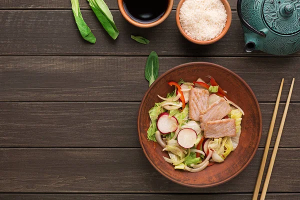 Salada com peixe, cebola, pimenta e rabanete em fundo de madeira — Fotografia de Stock