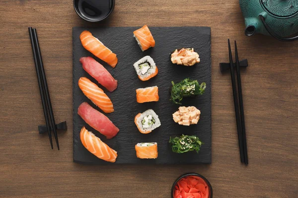 Pohled shora sada sushi maki a rohlíky poblíž čajník — Stock fotografie