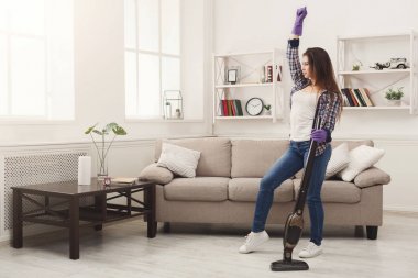 Mutlu kadın eve elektrikli süpürge ile temizlik
