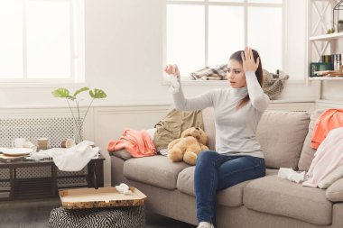 Dağınık odasında kanepede oturan çaresiz kadın