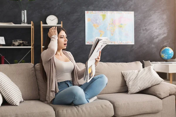 Joven mujer sorprendida leyendo el periódico — Foto de Stock