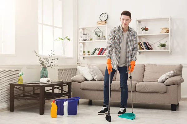 Jovem limpando casa, varrendo — Fotografia de Stock