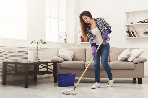 Młoda kobieta, sprzątanie domu z mopem — Zdjęcie stockowe