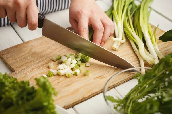 Vrouw snijden lente-ui voor salade — Stockfoto
