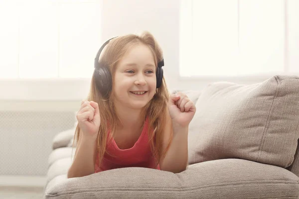 Niño bastante femenino escuchando música en auriculares —  Fotos de Stock