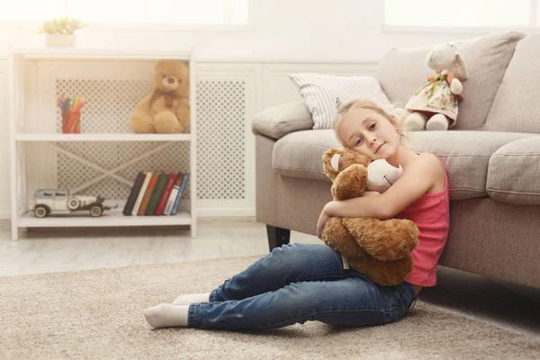 Šťastné děťátko ženské objímání její medvídek na podlahu doma — Stock fotografie